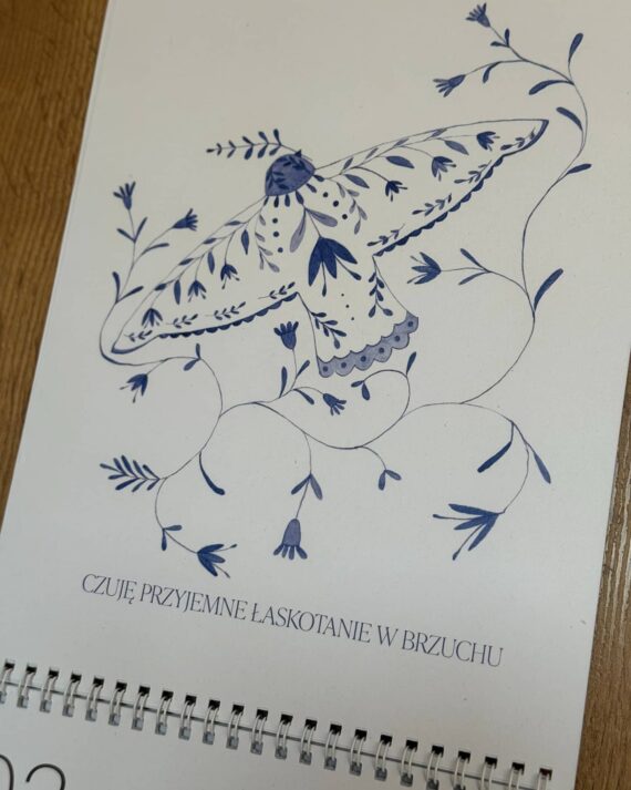 Blue floral illustration forming a butterfly on a white page, with vines and leaves in decorative pattern. The Polish caption at the bottom reads: “CZUJĘ PRZYJEMNE LASKOTANIE W BRZUCHU.”